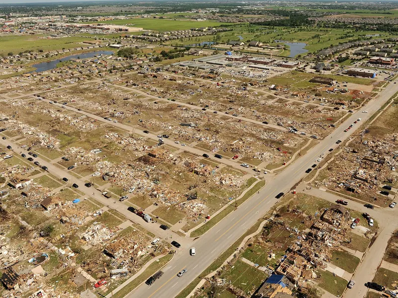 An aerial view of a neighbourhood with houses flattened into piles of wood and debris